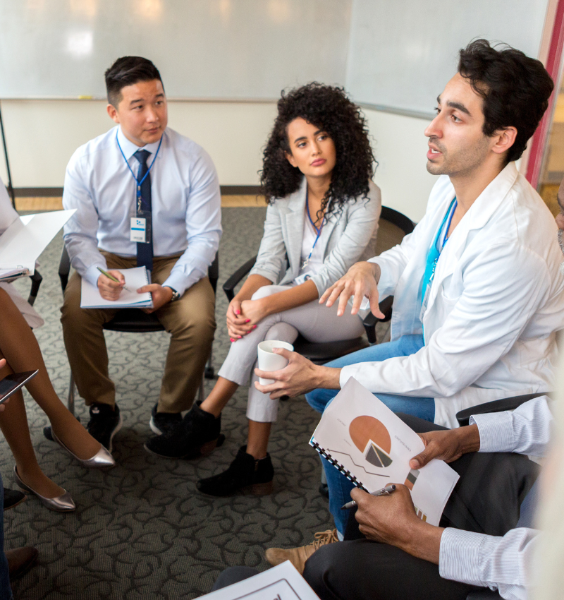 Image of health care professionals seated around in circle talking